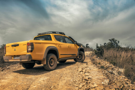 mitsubishi l200 triton savana 2024 amarelo rally trasiera parada em estrada de terra