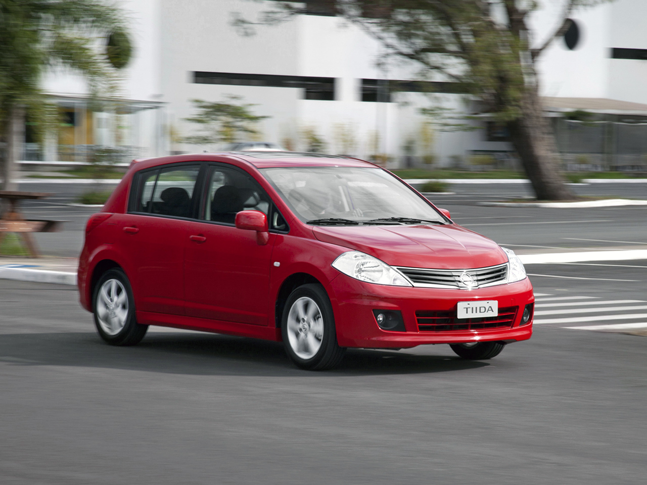 nissan tiida hatchback vermelho frente em movimento