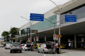 shutterstock pessoas desembarcando de carros na frente do aeroporto santos dumont rio de janeiro