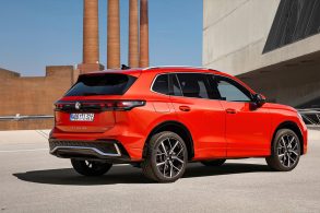 volkswagen tiguan 2024 vermelho traseira com fabrica ao fundo portal