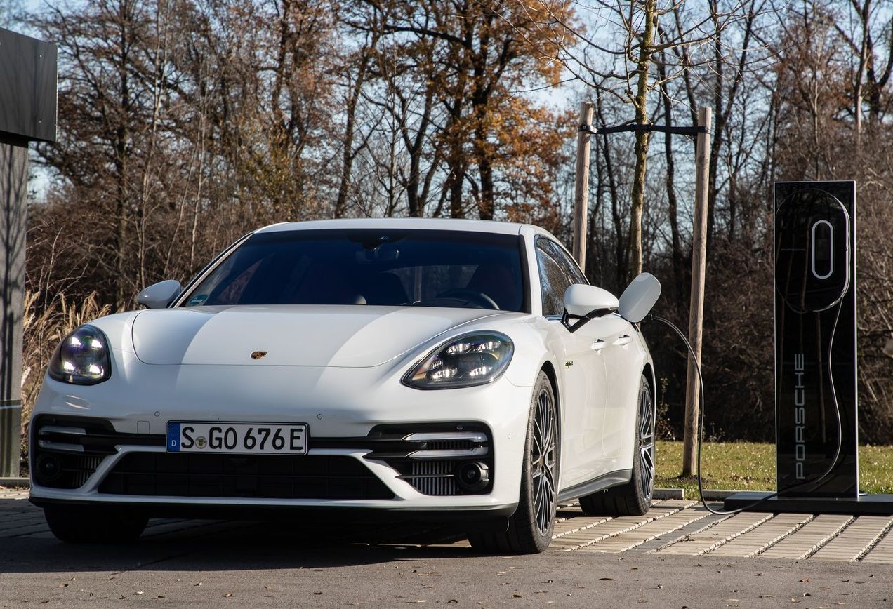 porsche panamera hybrid branco estacionando em ponto de recarga