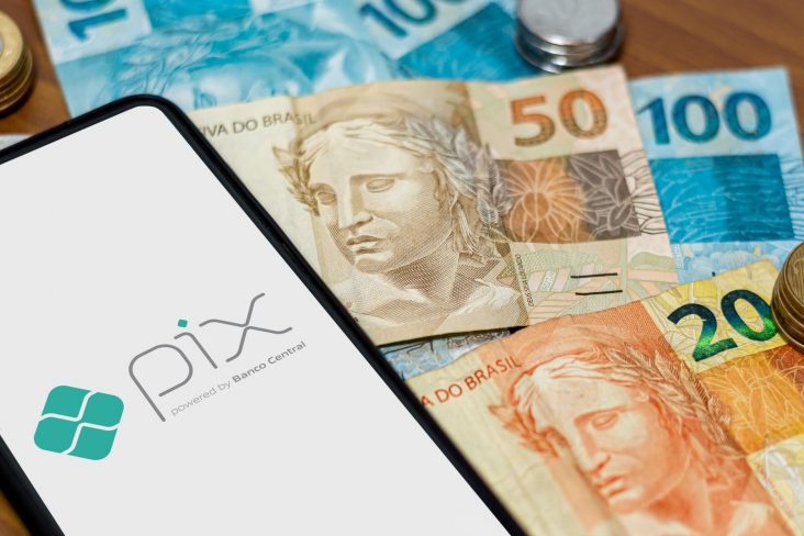 celular com logo pix sobre dinheiro foto etalbr shutterstock
