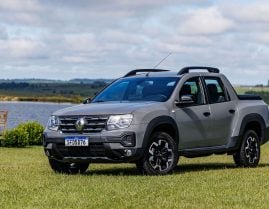 renault oroch iconic 1 6 cinza lune parado frente em gramado com lago ao fundo