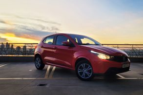 fiat argo drive 1 3 cvt 2023 vermelho frente parado com por do sol ao fundo