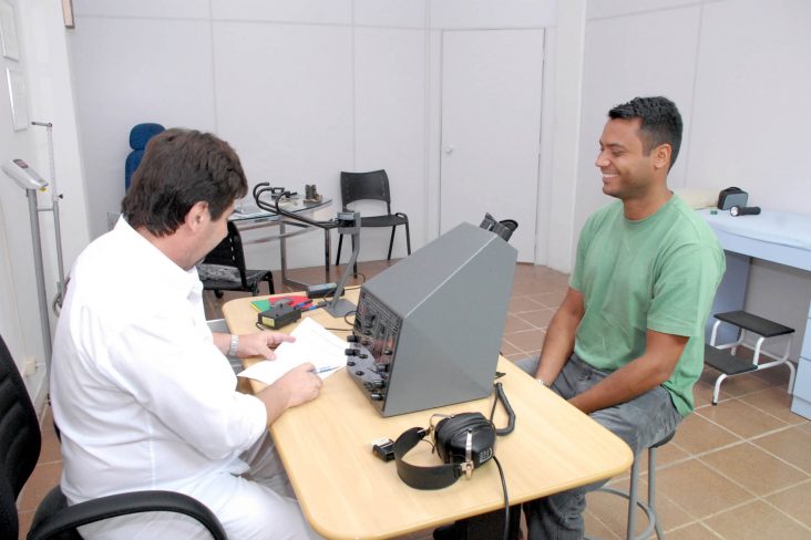 medico detran parana com paciente fazendo exame vista em maquina