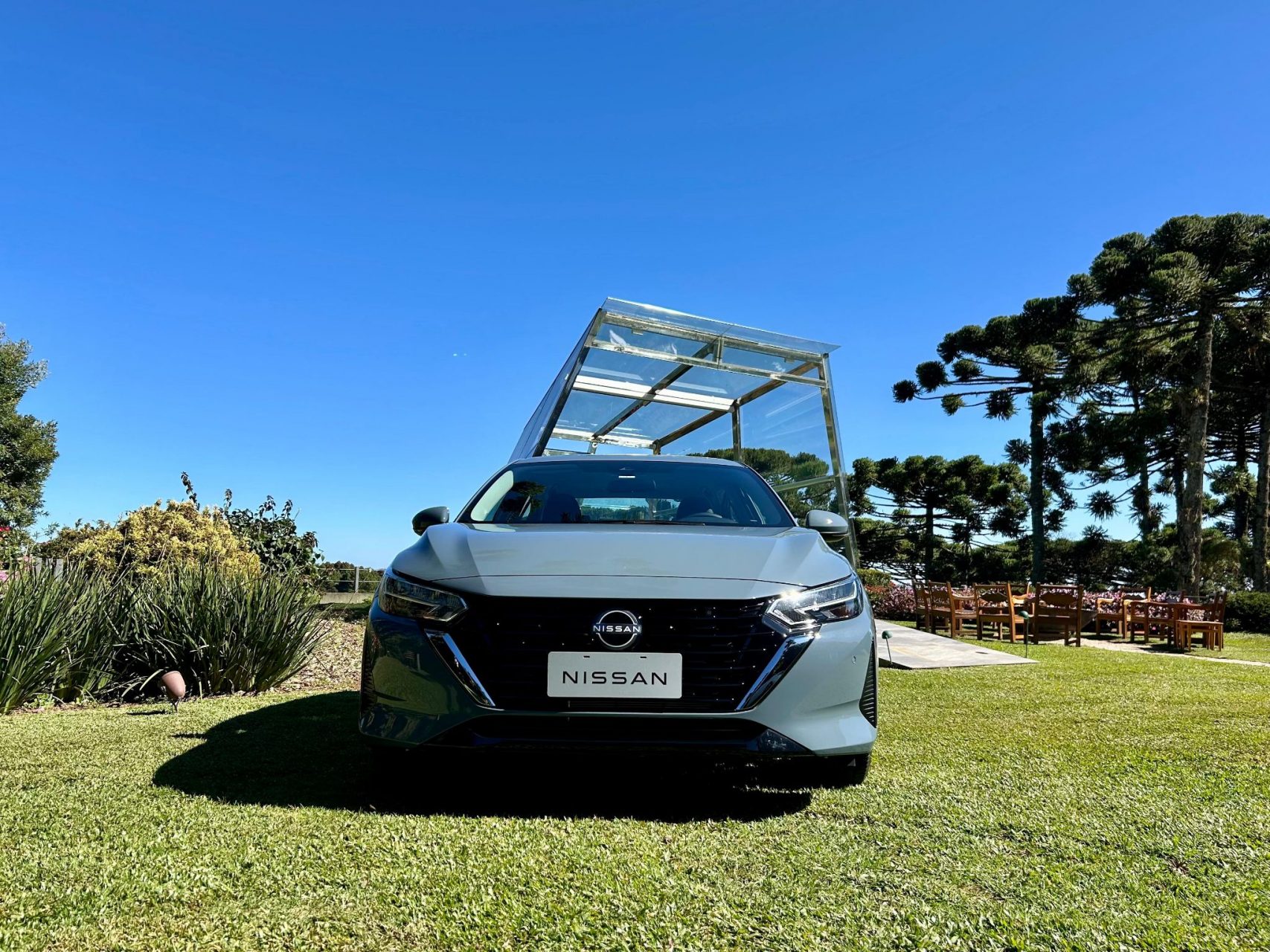 nissan sentra 2025 cinza atlantico estacionado em gramado visto de frente laurie andrade