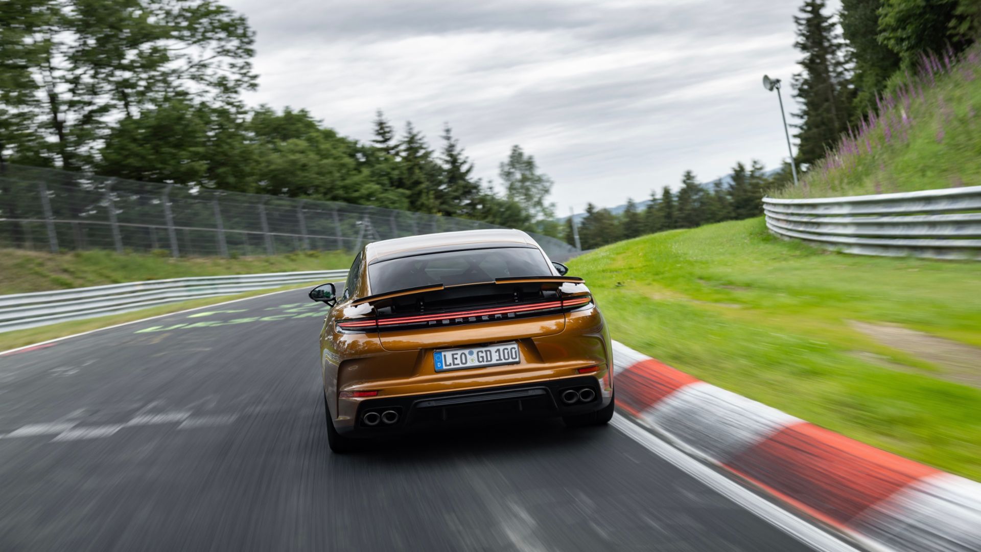 Nova versão porsche panamera nurburgring laranja traseira em movimento