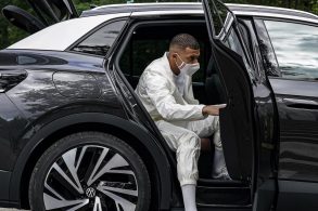 Kylian Mbappé saindo do parte traseira de um carro preto