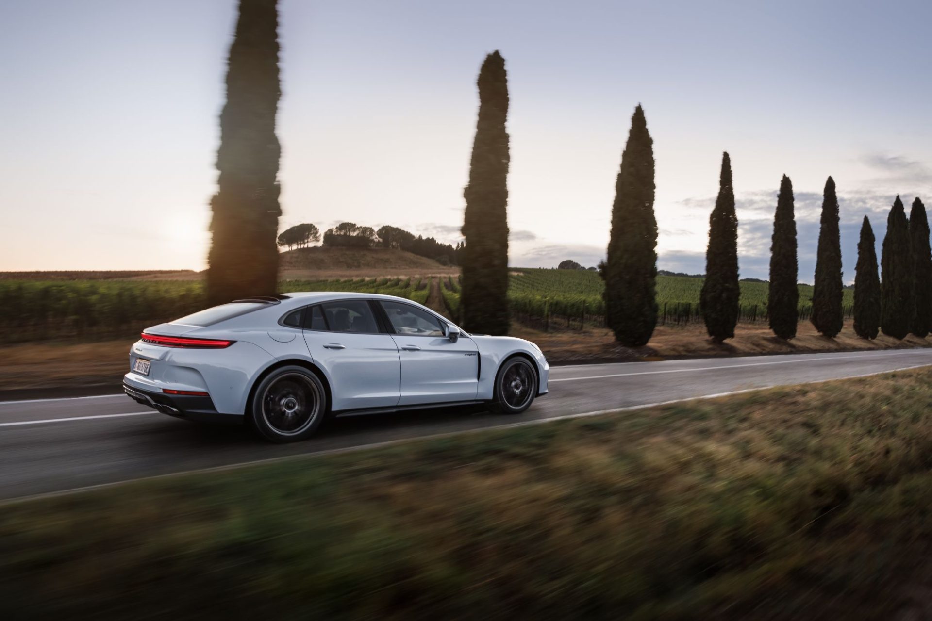 porsche panamera turbo s e hybrid 2025 branco lateral traseira em movimento rodovia