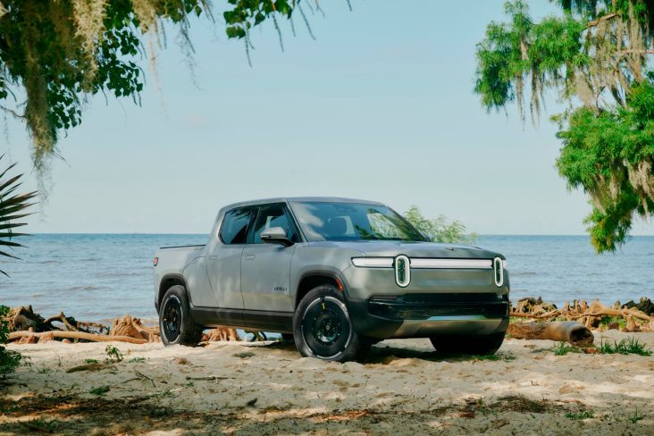 rivian r1t cinza frente parado em praia