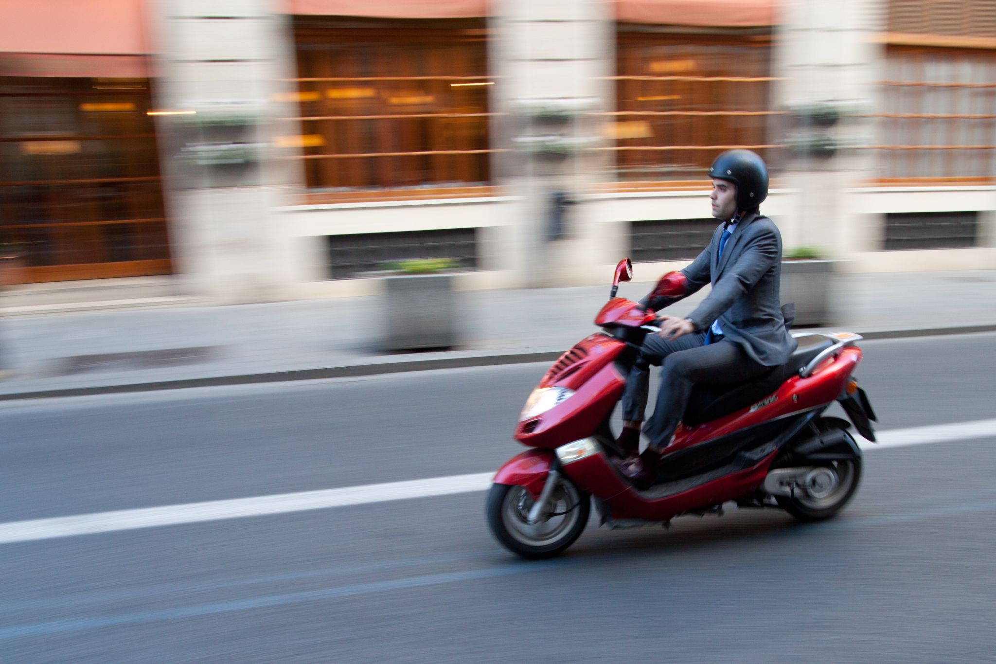 homem de terno indo para o trabalho de moto scooter