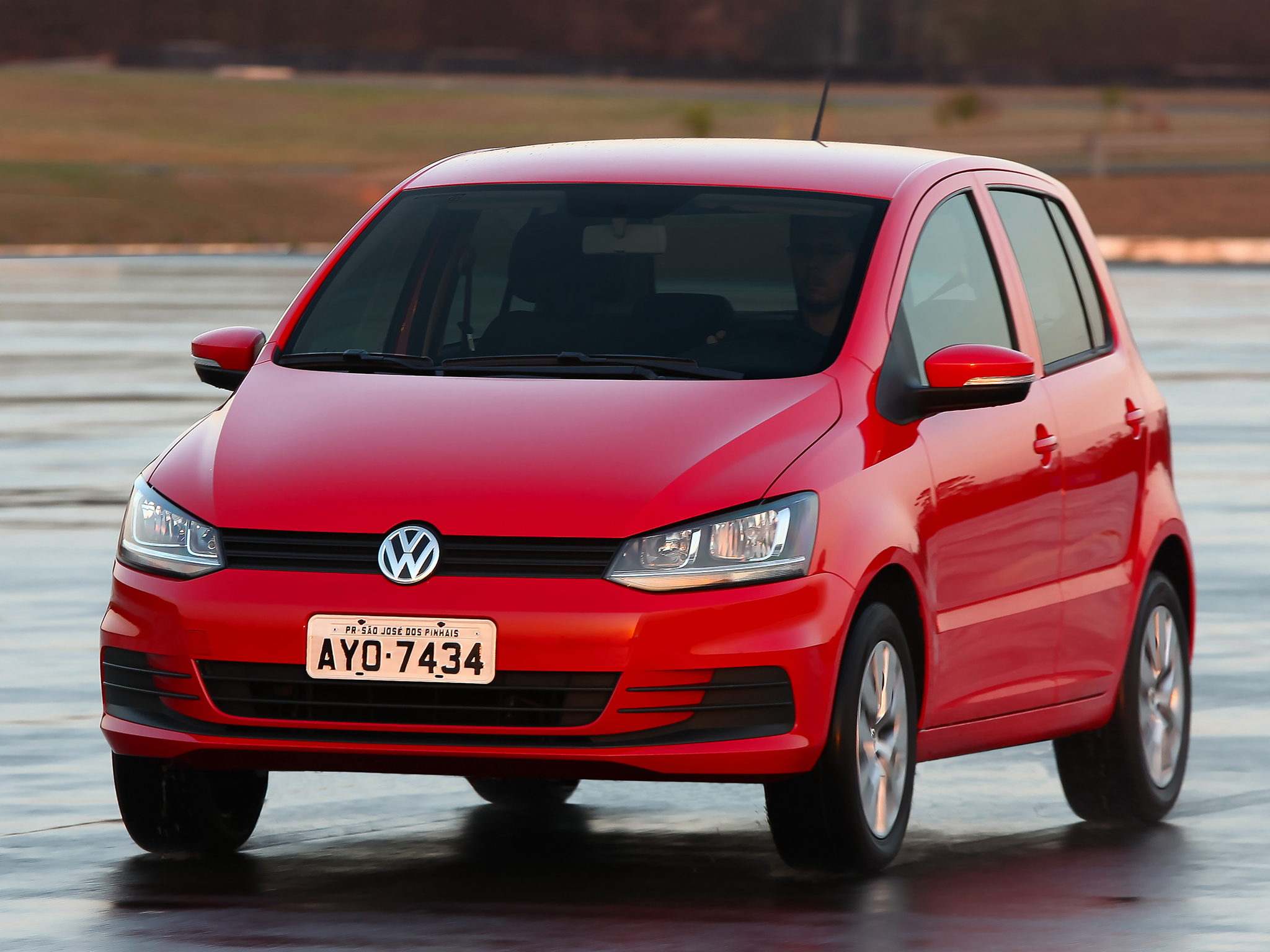 VOLKSWAGEN FOX 2015 VERMELHO EM MOVIMENTO FRENTE E LATERAL