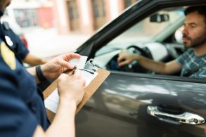 shutterstock policial multando motorista em carro multas de trânsito