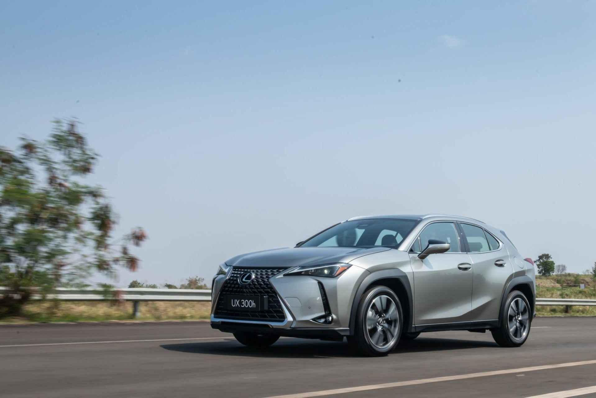 Lexus UX 300h prata em movimento visto de frente e de lado