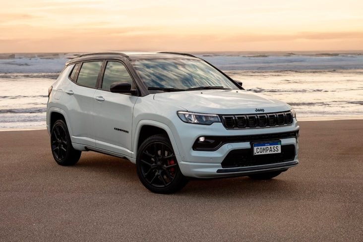 Jeep Compass branco parado na areia e ao fundo o mar