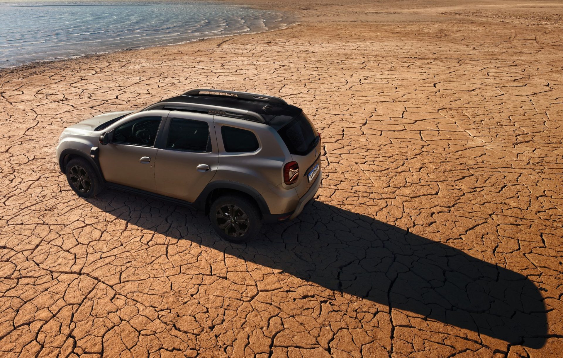 Renault Duster Iconic Plus 1 3 TCe turbo 2026 cinza Cassiopé com pacote outsider traseira vista de cima em deserto