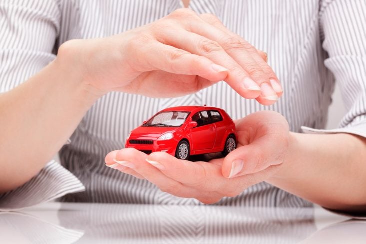 Uma pessoa segura com as mãos segura um carro de brinquedo