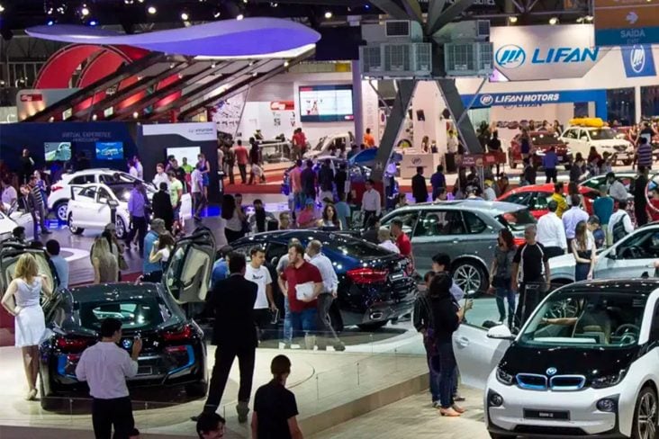 Salão do automóvel edição 2014 visto de cima com pessoas, automóveis e estantes das marcas