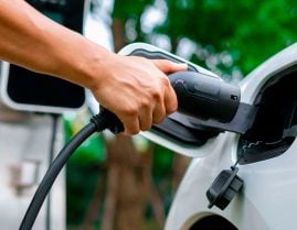carregadores de carros elétricos mão de pessoa plugando um carregador em carro elétrico ou híbrido plug in branco. autonomia carro elétrico