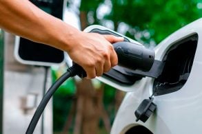 carregadores de carros elétricos mão de pessoa plugando um carregador em carro elétrico ou híbrido plug in branco. autonomia carro elétrico