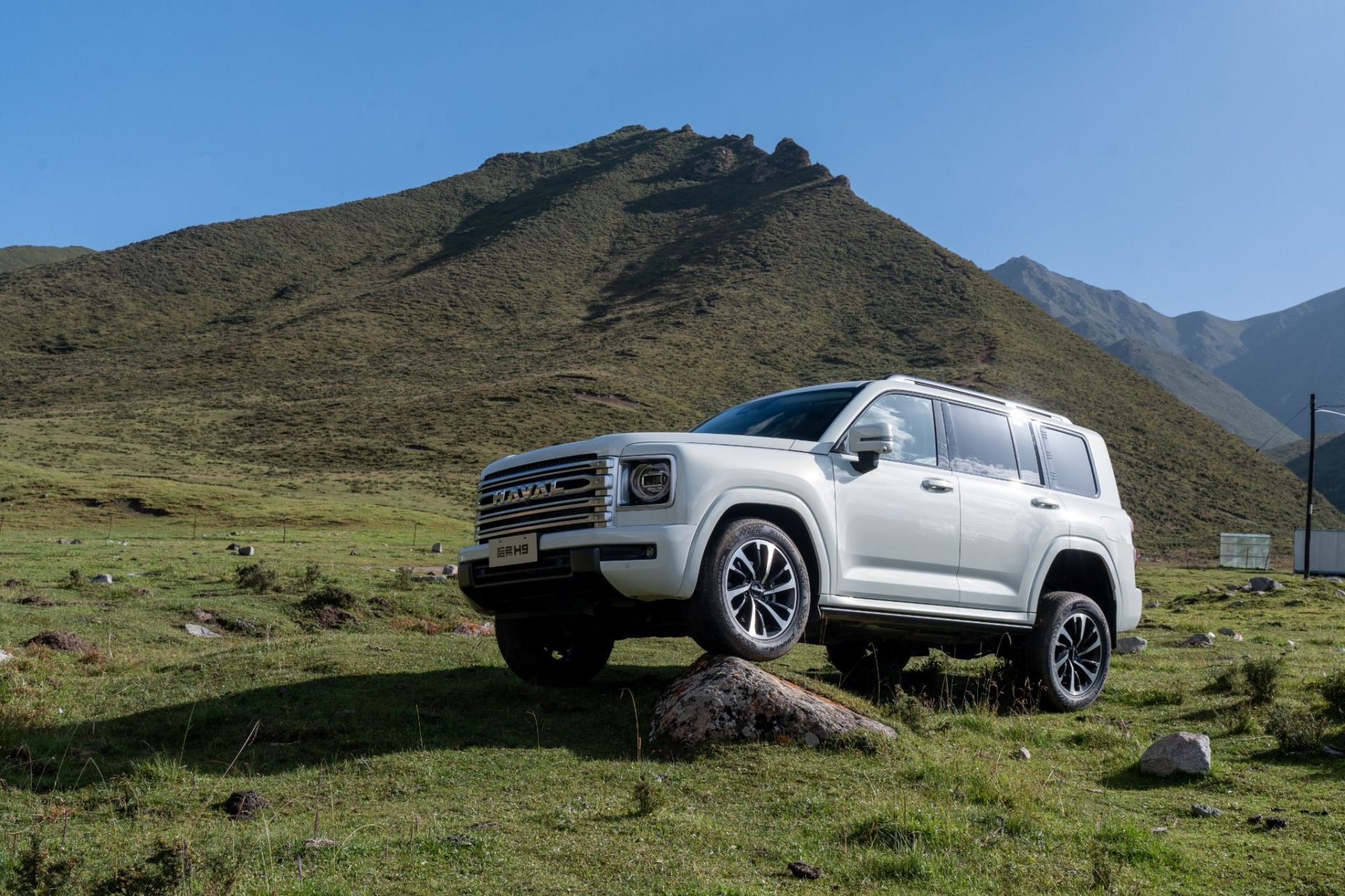 GWM haval h9 prata frente parado com roda em pedra