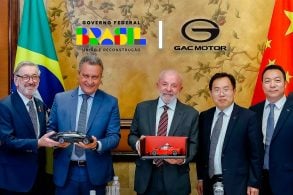 Presidente da república Luiz Inácio lula da silva com executivos da GAC Motor Montagem com as logos no fundo.