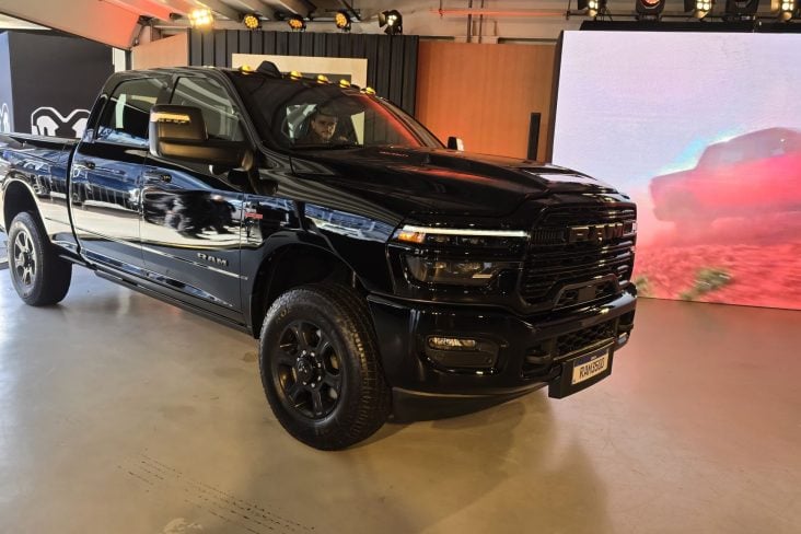 RAM 3500 preta em showroom lateral e frente