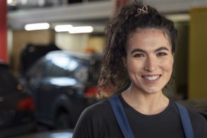 mulher posando em uma oficina mecânica