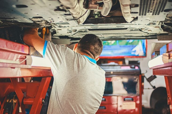 MECÂNICO REVISANDO A SUSPENSÃO DO CARRO