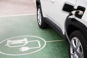 Carro elétrico branco carregando na vaga de carregamento