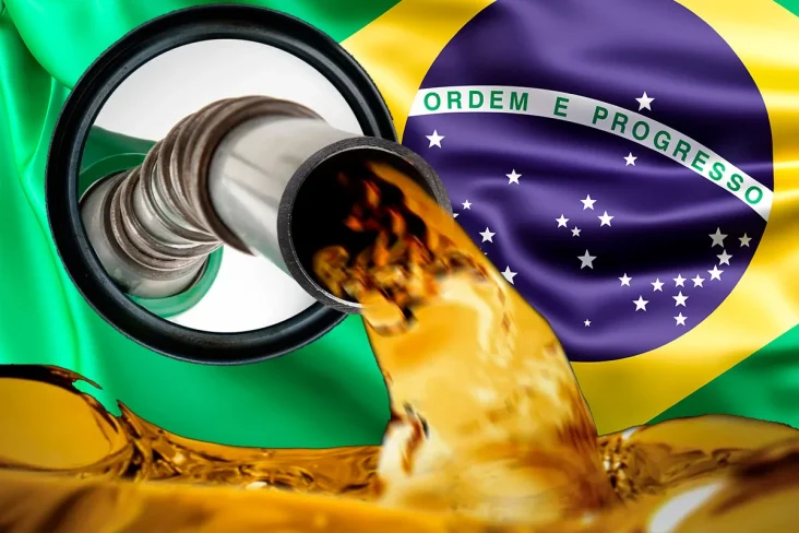 Pistola de abastecimento com a gasolina enchendo o tanque com a bandeira do Brasil ao fundo.