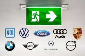 Símbolo de saída verde, logos das marcas GM, Volkswagen, Ford, Audi, Porsche, BMW, Mini Cooper, Mercedes e Volvo.