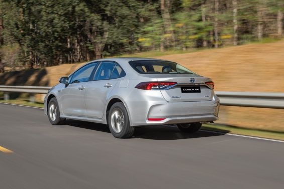 Toyota Corolla GLI Hybrid 2025 Prata Supernova traseira em movimento Toyota Corolla GLI Hybrid 2025 Prata Supernova traseira em movimento