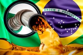 istola de abastecimento com a gasolina enchendo o tanque com a bandeira do Brasil ao fundo.