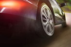 Rodas traseiras do carro em movimento na curva da estrada