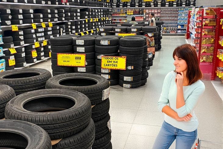 Uma mulher olhando pneu no supermercado