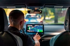 homem mexendo na multimídia de seu carro, tela desfocada