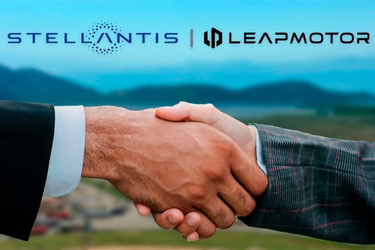 DOIS HOMENS APERTAM AS MÃOS ACIMA AS LOGOS DA Stellantis E Leapmotor, ao fundo cenario de uma porto desfocado.