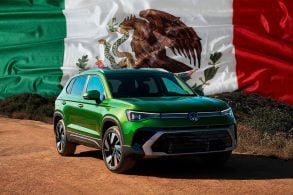 Volkswagen Taos parado no topo de um morro. Ao fundo das montanhas bandeira do México.