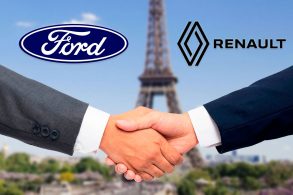 Duas mãos masculinas se cumprimentam do lado esquerdo ao fundo a logo da Ford e na direita a Logo da Renault.