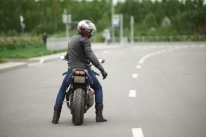 shutterstock motociclista moto esportiva na estrada visto de costa