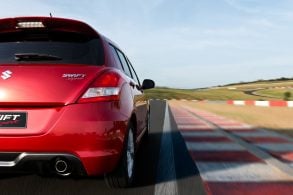 Suzuki Swift Sport vermelho traseira em movimento autodromo