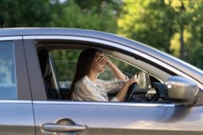 mulher dirigindo cansada com dor de cabeça shutterstock