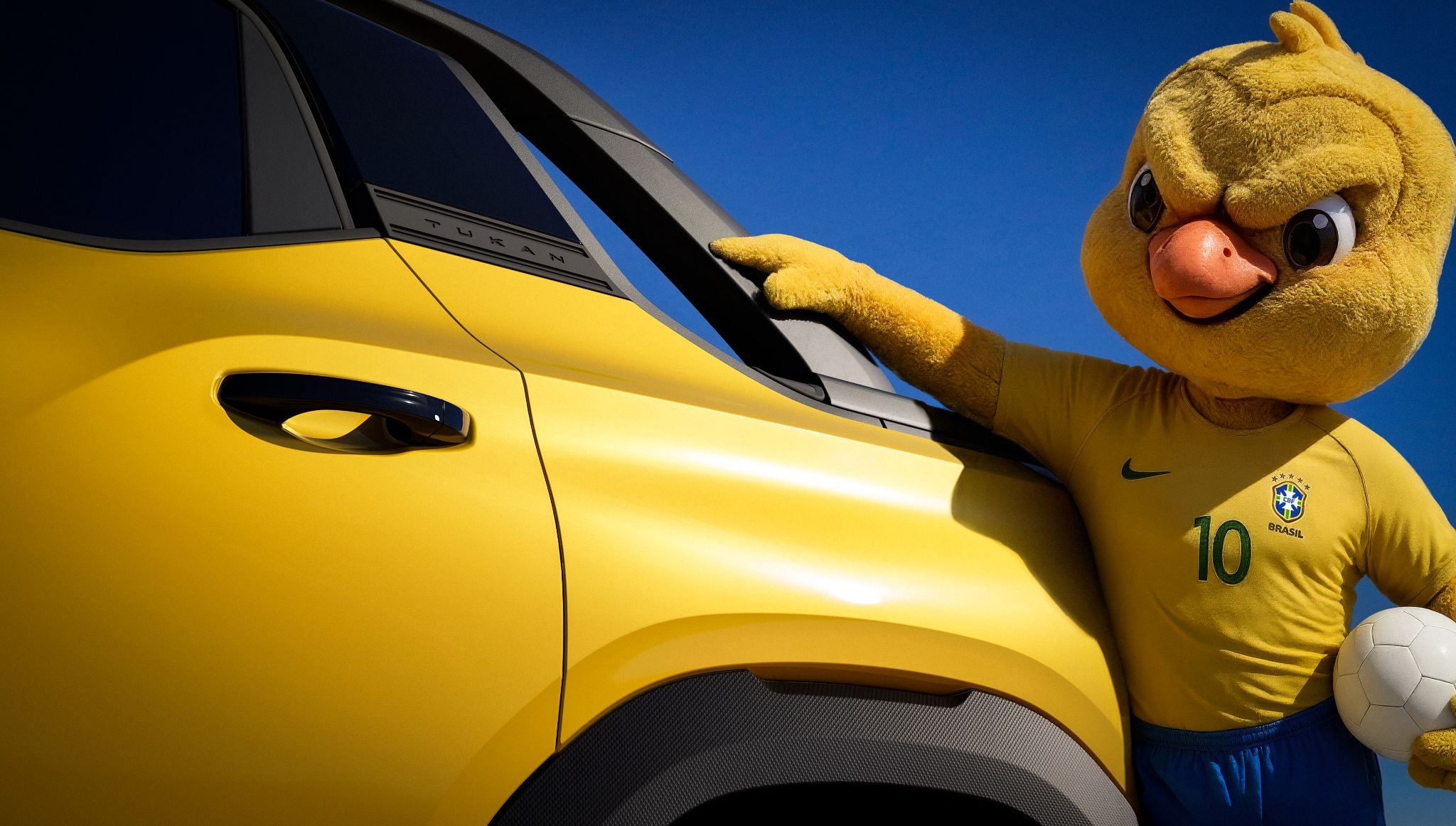 Volkswagen Tukan teaser lateral da caçamba pintura amarelo canário fosco com mascote da seleção brasileira de futebol