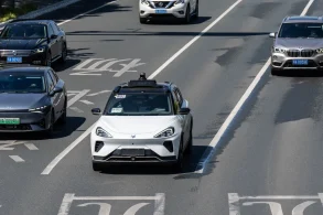 a white robotaxi from baidu on a highway with other cars jpg