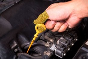 óleo motor nível vareta, mão de homem puxando a vareta de óleo do carro, mão reluzente dourada