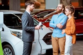 vendedor mostra carro eletrico usado para casal