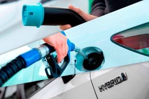 Primeira imagem: uma mão segura um carregador de carro elétrico. Segunda imagem: uma mão segura apistola de combustivel de carro. Terceira imagem: emblema carro hibrido