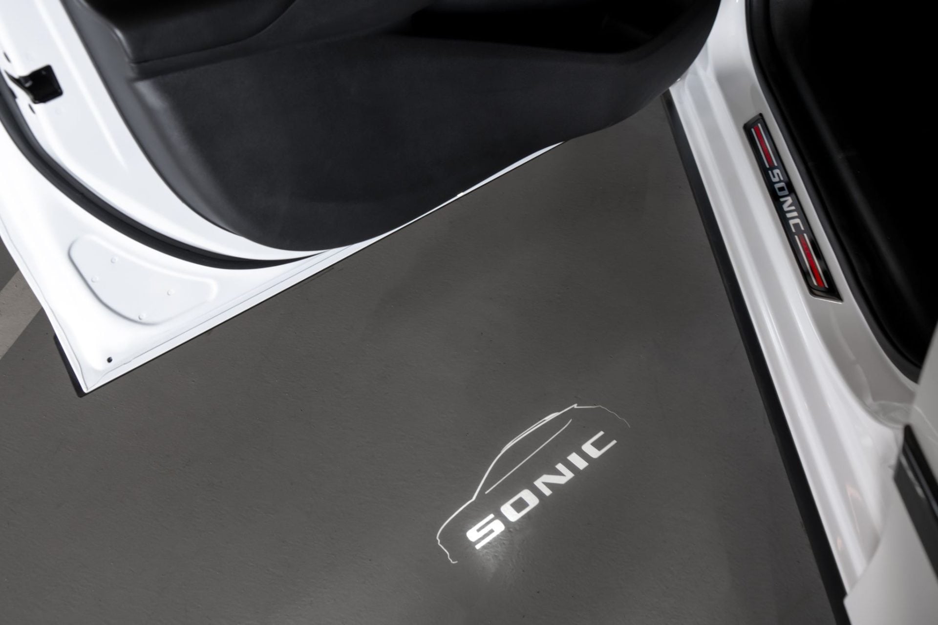 Chevrolet Sonic RS 2026 com acessórios projeção na porta