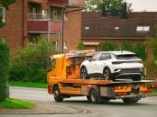 A,Flatbed,Tow,Truck,Transporting,A,Damaged,Car,On,The